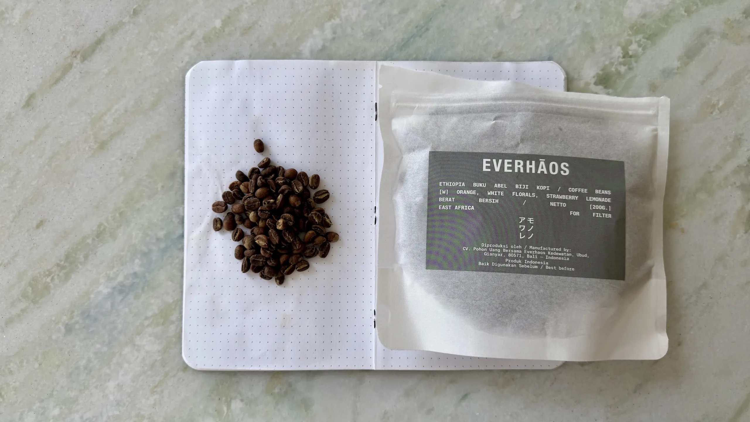 Everhaos Ethiopia Buku Abel coffee bag and small roasted beans on a dotted notebook