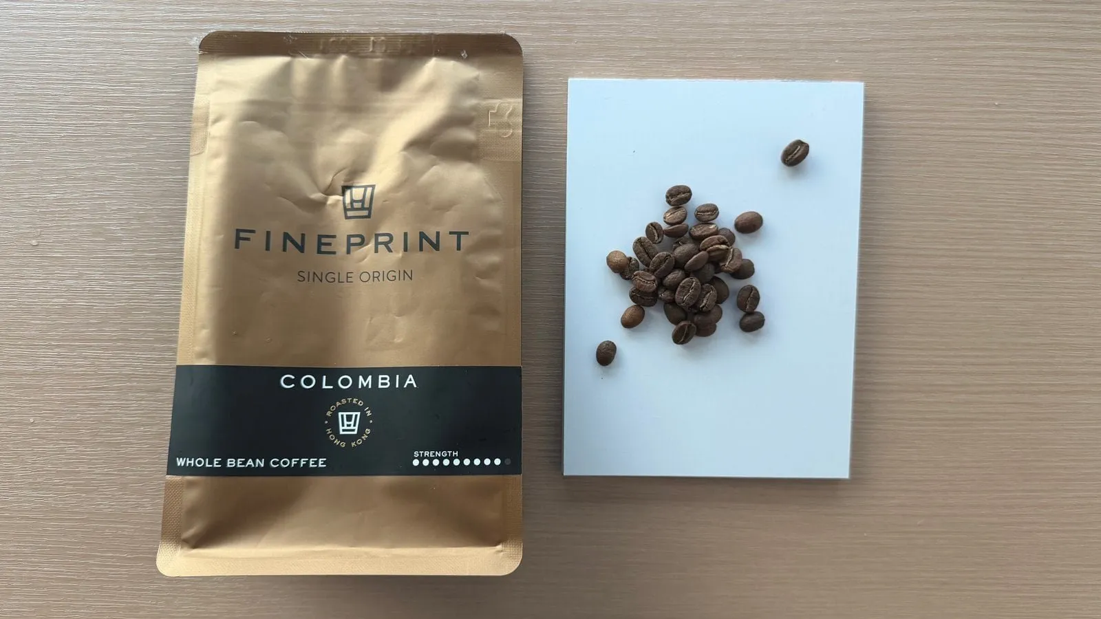 Freshly roasted Colombia single-origin coffee beans displayed on a white surface, highlighting quality and freshness for coffee enthusiasts.