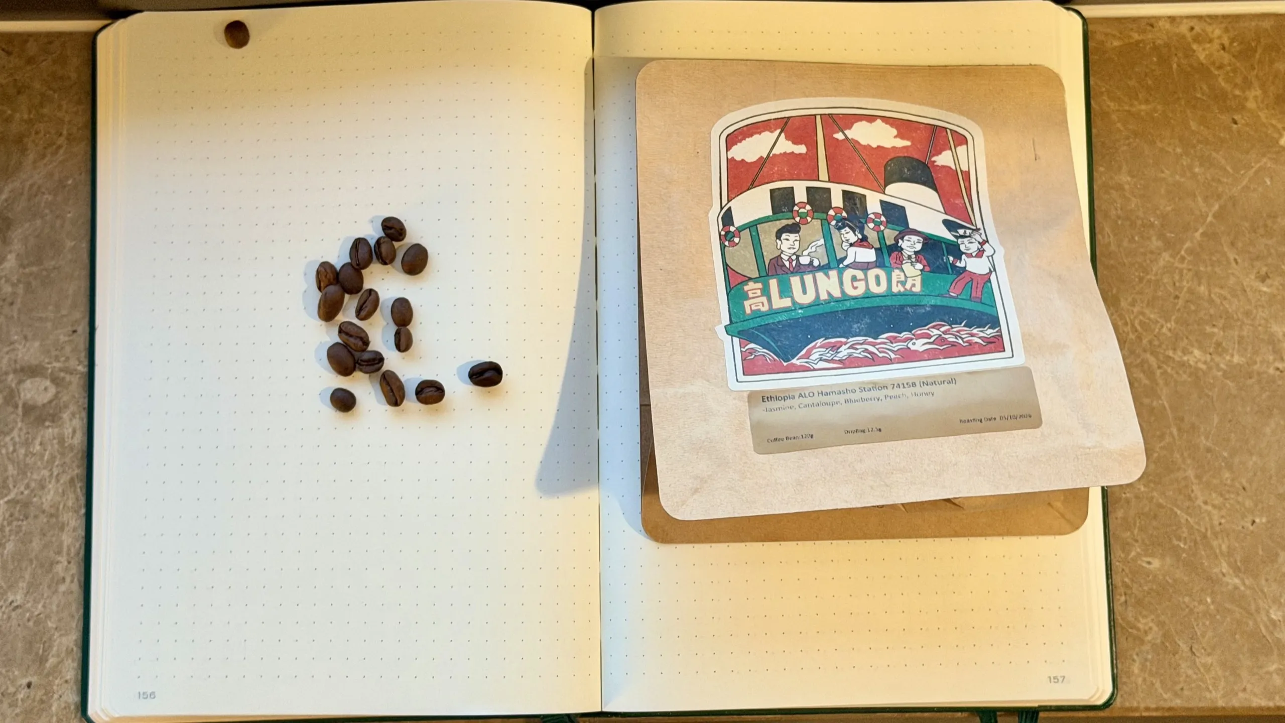 Lungo Ethiopia ALO Hamasho Station 74158 Natural bag with whole beans on dotted notebook