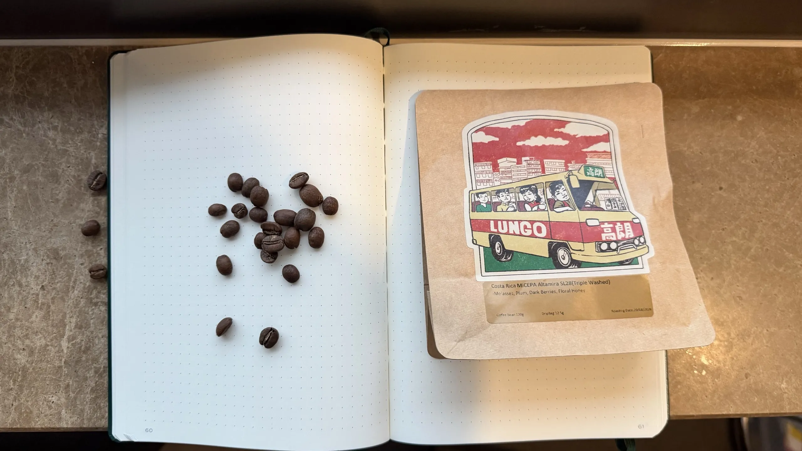 Lungo MICEPA Altamira SL28 bag beside roasted beans on a grid notebook