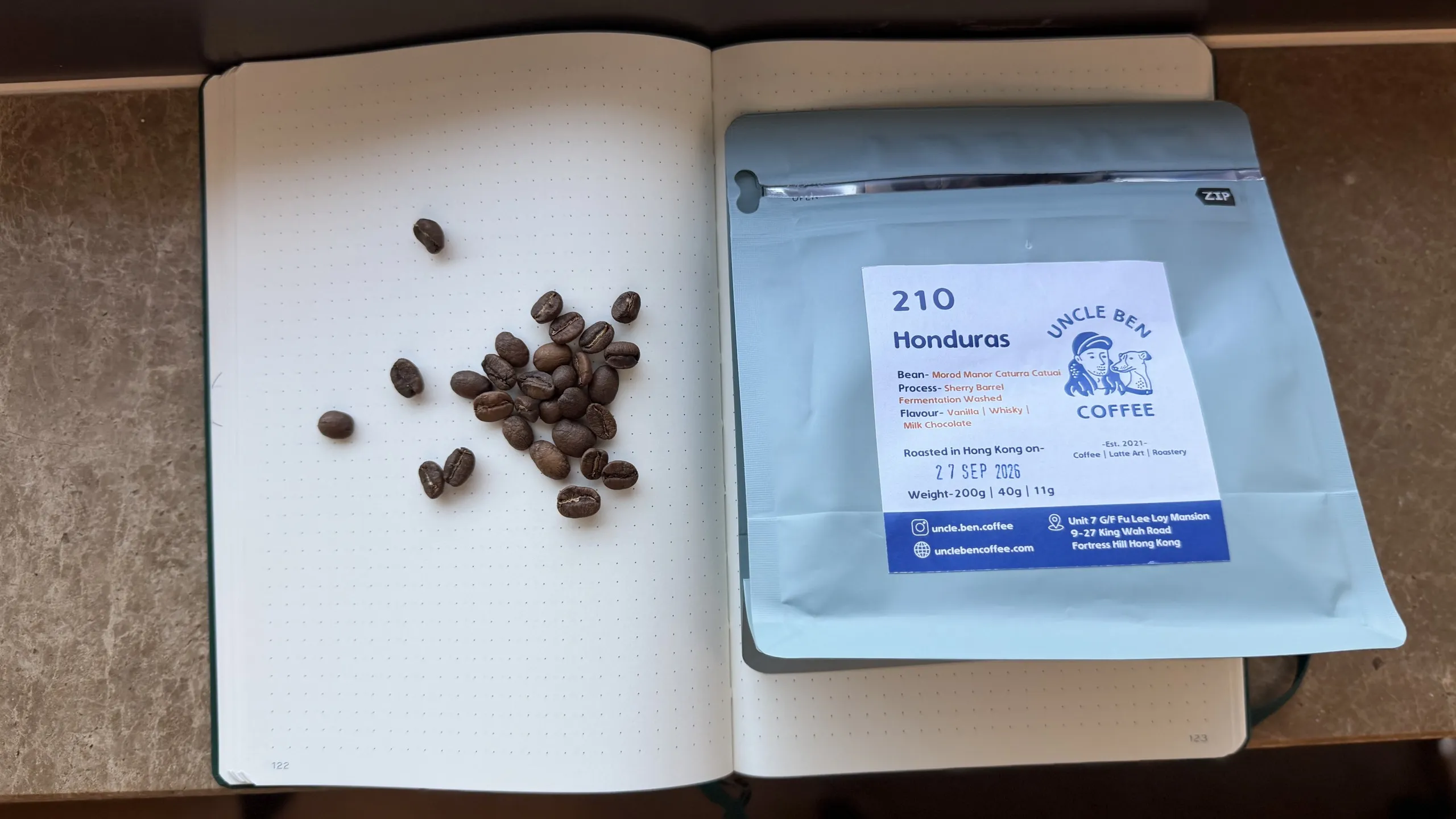 Uncle Ben Coffee 210 Honduras bag and beans on a grid notebook
